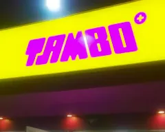 Letrero luminoso de Tambo con fondo amarillo y letras magenta