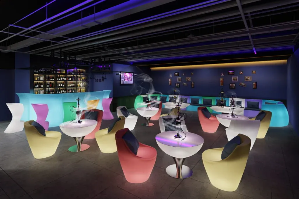 Mobiliario LED de colores vibrantes en bar nocturno con ambiente moderno