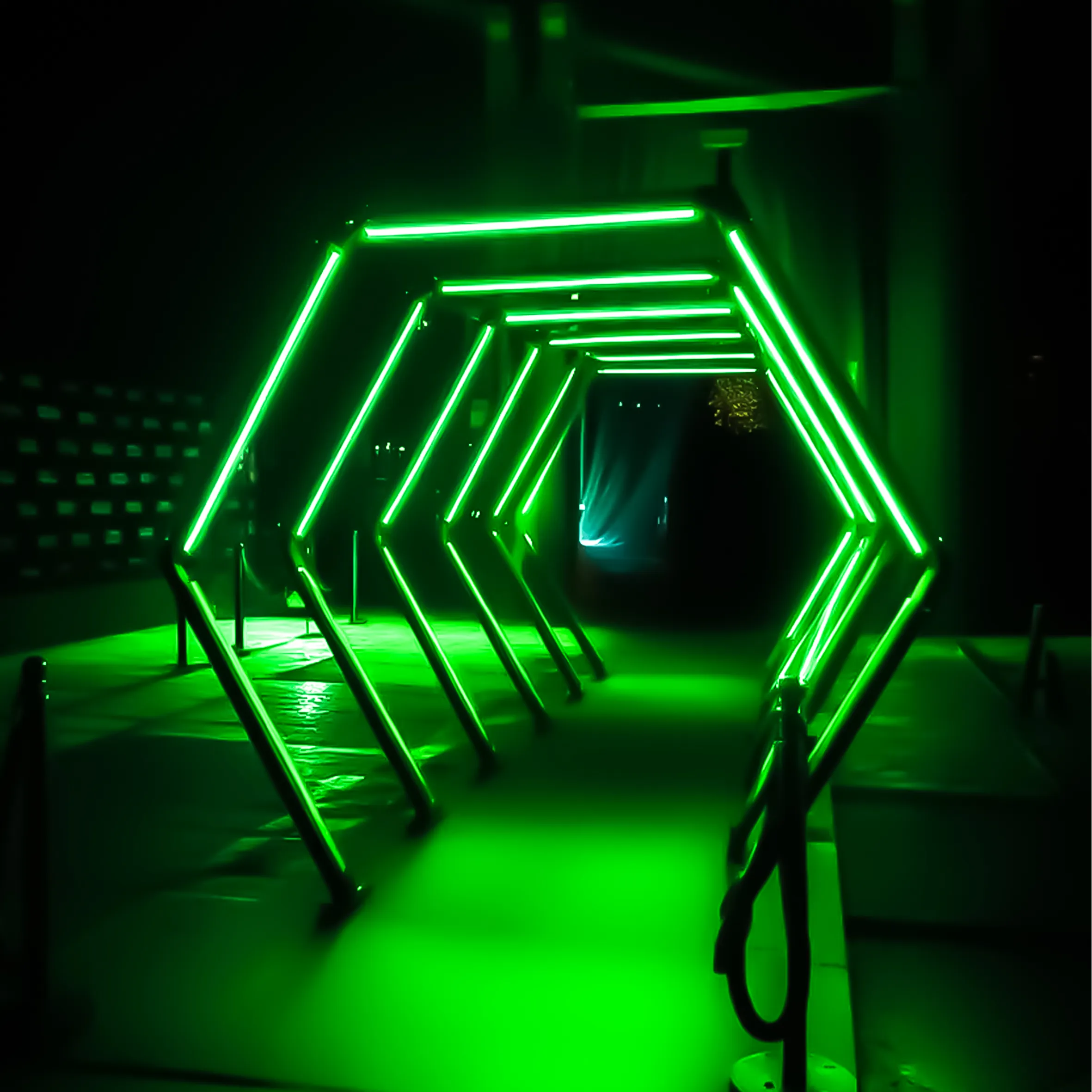 Túnel de ingreso a evento decorado con estructuras LED verdes