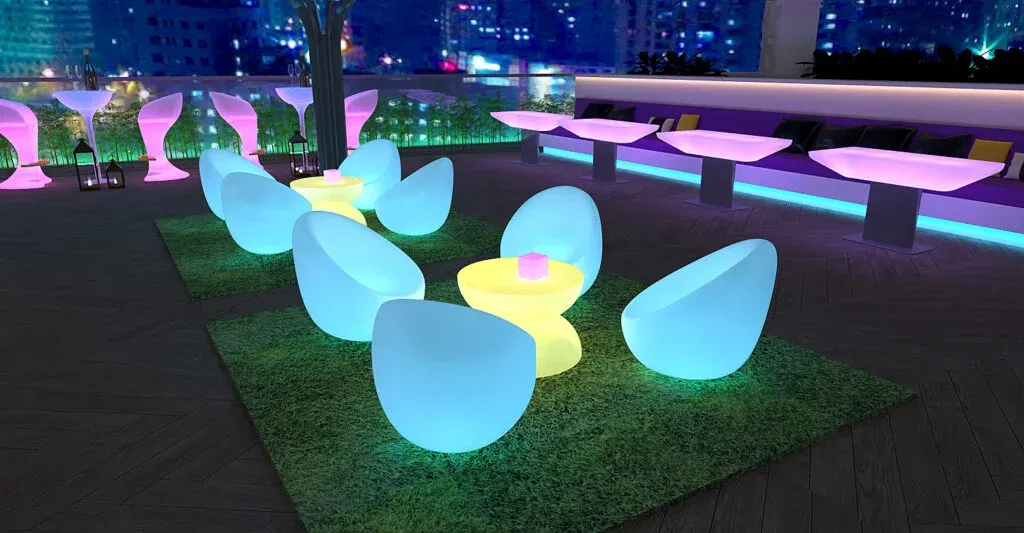 Sillas LED iluminadas al aire libre sobre césped artificial en terraza nocturna