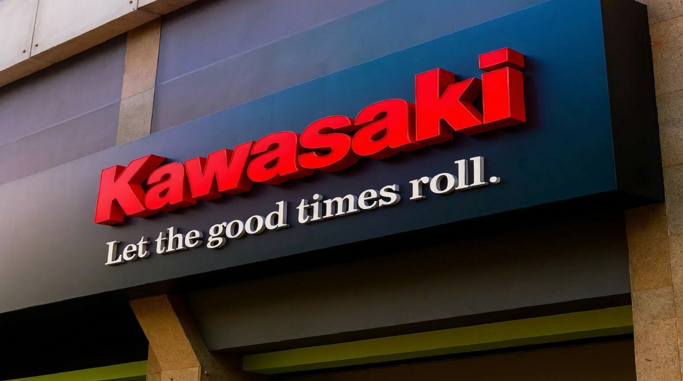 Letras corporeas rojas con la marca Kawasaki acompañado por debajo con un eslogan de letras pequeñas en color blanco.